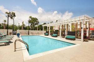 查尔斯顿Home2 Suites By Hilton Mt Pleasant Charleston的一座带躺椅的度假村的游泳池和一座大楼