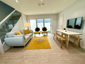 浦耳Brand New 3 Bedroom House -Sleeps 6 - Free Parking - Great Location - Fast WiFi - Smart TV - sleeps 6! Close to Poole & Bournemouth & Sandbanks的客厅配有沙发和桌子
