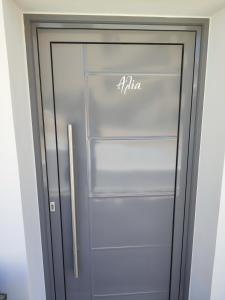 波多河丽Niriides Apartments的冰箱上装有安咪奈的玻璃门