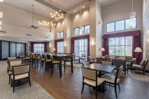 波威圣地亚哥波威希尔顿恒庭旅馆&套房酒店的用餐室设有桌椅和窗户。