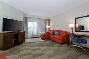 波威圣地亚哥波威希尔顿恒庭旅馆&套房酒店的客厅配有红色沙发和平面电视