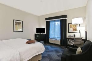 贝尔维尤贝尔维尤市中心/西雅图汉普顿酒店的酒店的客房 - 带一张床、椅子和窗户