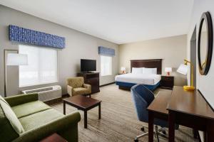 西萨克拉门托西萨克拉门托汉普顿旅馆及套房酒店的配有一张床和一张书桌的酒店客房