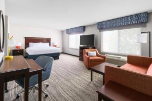 千橡市千橡市汉普顿套房酒店的配有一张床和一张书桌的酒店客房