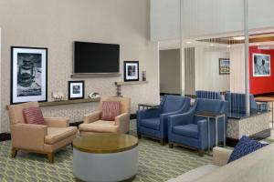 国家海港亚历山德里亚区纳什纳尔哈勃尔希尔顿恒庭旅馆&套房酒店的一间设有椅子和平面电视的等候室