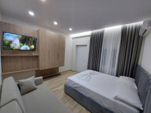 伏罗拉SOLE INN的一间卧室配有一张床、一张沙发和一台电视。