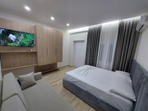 伏罗拉SOLE INN的一间卧室配有一张床、一张沙发和一台电视。