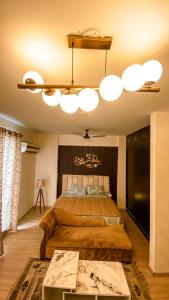 勒克瑙Caramel DLF My Pad的一间卧室配有一张大床和一个吊灯。