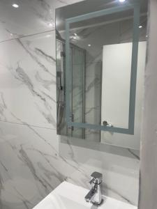 伦敦Newly renovated studio in Acton的白色的浴室设有水槽和镜子