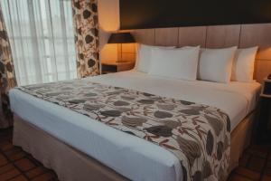 瓜鲁雅Ferraretto Guarujá Hotel & Spa的一张位于酒店客房的床铺,配有一张大床