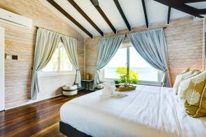 伯利兹城Shaka Caye All inclusive Resort的卧室设有一张带窗户的白色大床