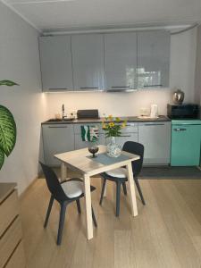 里加Apartment Upeņu的一间带桌椅的厨房和一间带白色橱柜的厨房