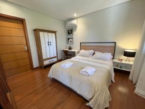 特雷索波利斯Charmoso Chalet的一间卧室配有一张大床和两条毛巾