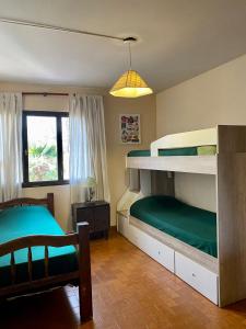 门多萨Open House Hostel的一间卧室配有两张双层床和椅子