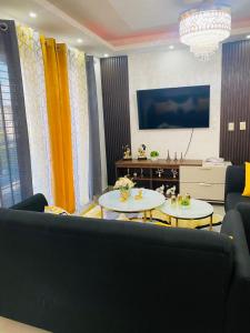 圣地亚哥洛斯卡巴Confortable y lujoso apartamento en santiago的客厅配有两张桌子和一张沙发