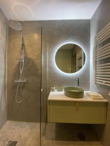 波瓦-迪瓦尔津Mercadoflat的浴室配有盥洗盆和带镜子的淋浴