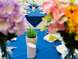 霍利Acorn Lodge Hotel Gatwick & Parking的一排蓝色的桌子,花瓶里放着鲜花