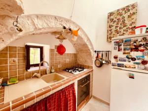 因帕拉Il trullo di Rosa的厨房配有水槽和炉灶 顶部烤箱