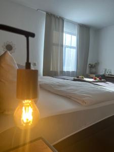 文登Hotel Restaurant Zum Landmann的一间卧室配有一张带灯和窗户的床
