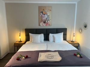 文登Hotel Restaurant Zum Landmann的一间酒店客房,床上摆放着鲜花