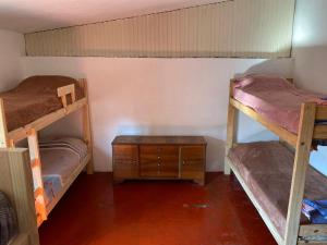 罗萨里奥Alojamiento hostel Lodeolga "La Florida"的客房设有两张双层床和一张木桌。