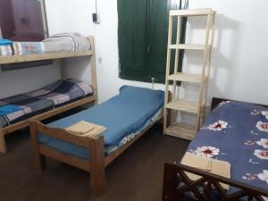 罗萨里奥Alojamiento hostel Lodeolga "La Florida"的客房设有两张双层床和一张桌子。