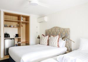 拜伦湾拜伦勋爵汽车旅馆的配有2张白色床的客房内的2张床