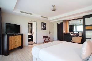 普纳奥亚Te Moana Tahiti Resort的一间卧室配有一张床和一台平面电视
