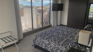 加拉加斯HOTEL CHACAO SUITES的卧室设有黑白床和窗户。