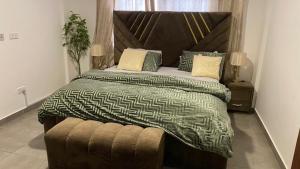 阿克拉Accra Luxury apartments at Oasis Park Residences的一间卧室配有一张大床和木制床头板