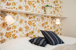 赖特维克布鲁恩特加登酒店的一张带枕头的床和一堵鲜花的墙壁