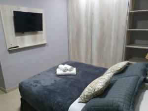 伊瓜苏港Martina Apart的一间卧室配有一张床,床上配有两张折叠毛巾