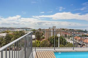 悉尼'Bondi Fairview' Coastal Panorama with Balcony的设有一个泳池公寓的阳台,享有风景。