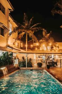 凯恩斯凯恩斯皇庭酒店的一座游泳池,在晚上在建筑物前
