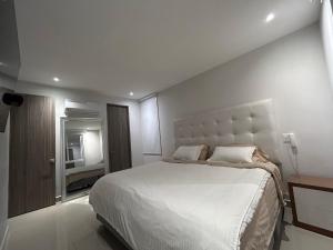 巴兰基亚HERMOSO!! MODERNO, UBICACION EXCLUSIVA!! 2 ALCOBAS的白色卧室设有一张大床和电视。