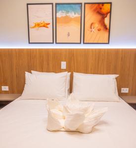 乌巴图巴Ubatuba Eco Hotel的卧室配有一张白色床,墙上挂有4张照片