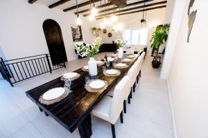 锡盖图马尔马切伊Casa Bolta Rece的一间带长桌和白色椅子的用餐室