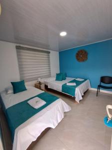 普罗维登西亚Mary & Matt lodge的一间设有两张床和蓝色墙壁的客房