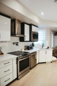 多伦多Toronto Junction Hideaway的厨房配有不锈钢用具和白色橱柜