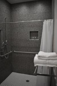 休斯顿Blue Star Inn的浴室设有淋浴,并在凳子上备有毛巾