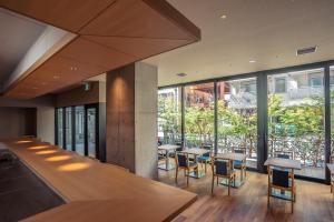 大阪谷町君Hotel 難波77的餐厅设有桌椅和大窗户。