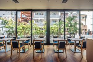 大阪谷町君Hotel 難波77的餐厅设有桌椅和大窗户。