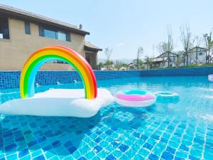 运城运城云兮故里·班马家度假酒店的水中带彩虹和两个充气池的游泳池