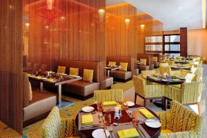 阿布扎比阿布扎比万豪国贸中心庭院酒店的一间带桌椅的用餐室和一间餐厅