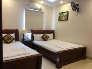 河内Phúc Quý Hotel - 149B Lê Duẩn - by Bay Luxury的卧室配有两张床,墙上配有风扇