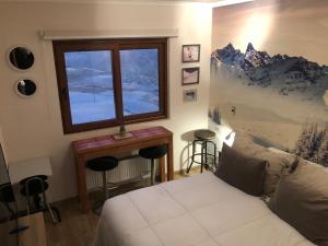 Lo BarnecheaDepartamento residencial Valle Nevado的一间卧室设有一张床、一个窗口和一张桌子