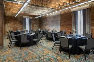 新奥尔良Courtyard by Marriott New Orleans Warehouse Arts District的一间会议室,配有桌椅和砖墙