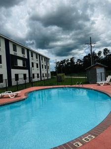 查尔斯湖Quality Inn & Suites Lake Charles的大楼前的大型蓝色游泳池