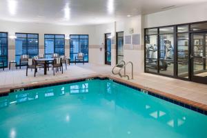 萨福克萨福克切萨皮克庭院酒店的一个带用餐区、桌子和椅子的游泳池