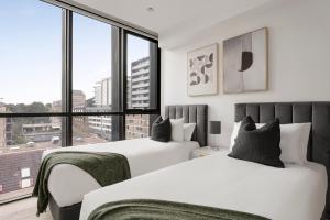 悉尼Urban Rest North Sydney Apartments的卧室设有两张床和大窗户